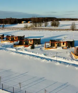 Capri mobile homes with metallic anthracite cladding in winter covered with snow 