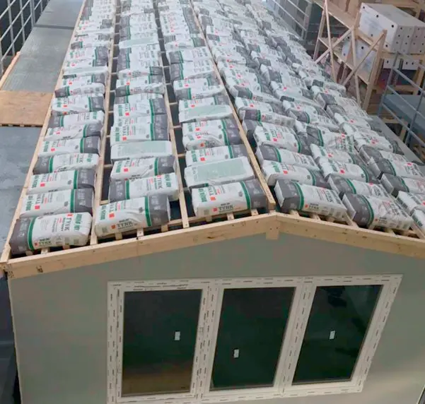 Imágenes de la casa móvil durante la prueba de resistencia del techo, en el borde hay muchos sacos de cemento que pesan un total de 7 toneladas.
